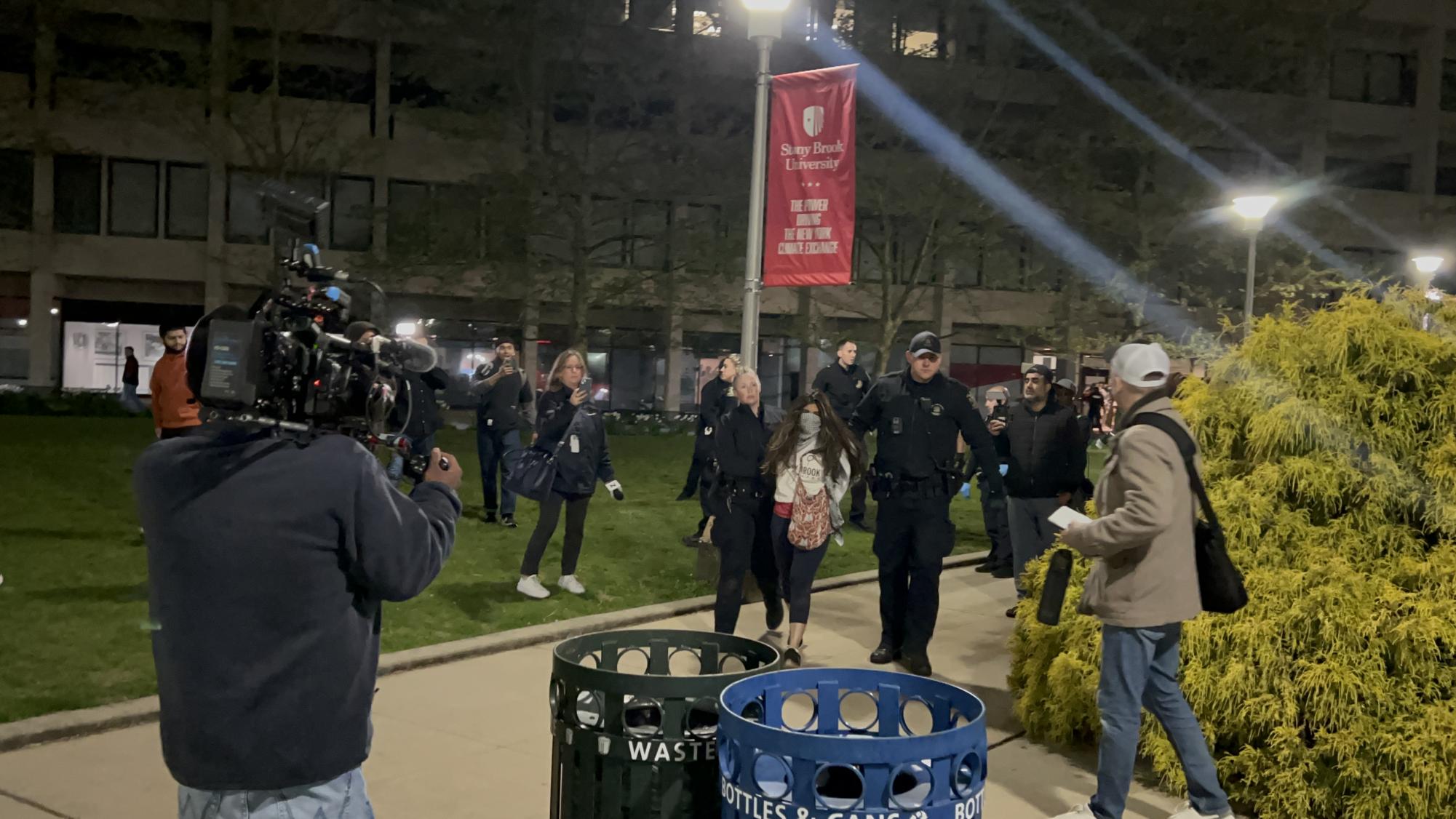 A protestor being escorted away from the Staller steps by police